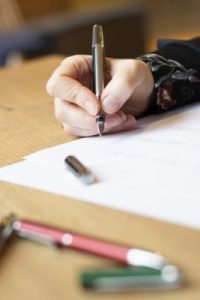 Frau hält Füller im Dreifingergriff um eine verbesserte Handschrift zu üben